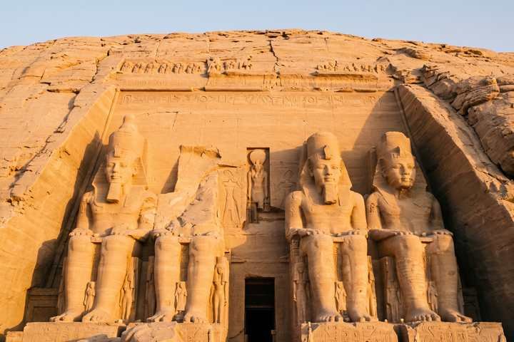 واجهة أبو سمبل المنحوتة في الجرف، بتماثيل رمسيس الثاني الأربعة الجالسة وباب المعبد المظلم في الوسط
